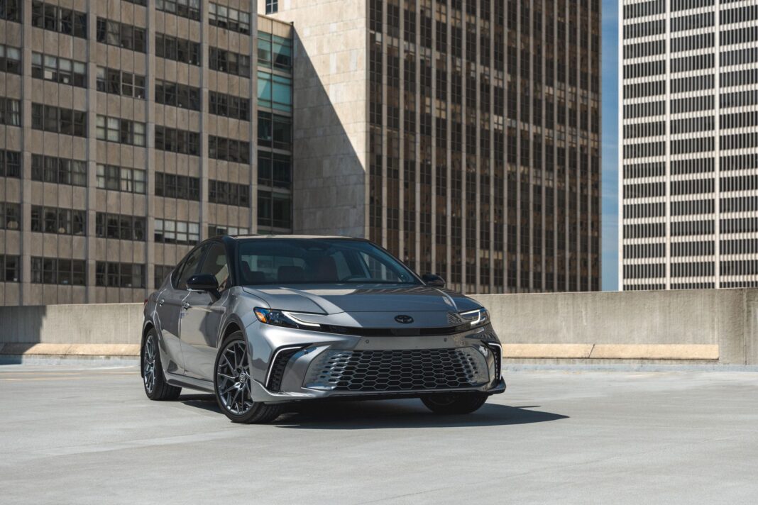 2025 Toyota Camry Hybrid parked on a city street with modern design and LED headlights