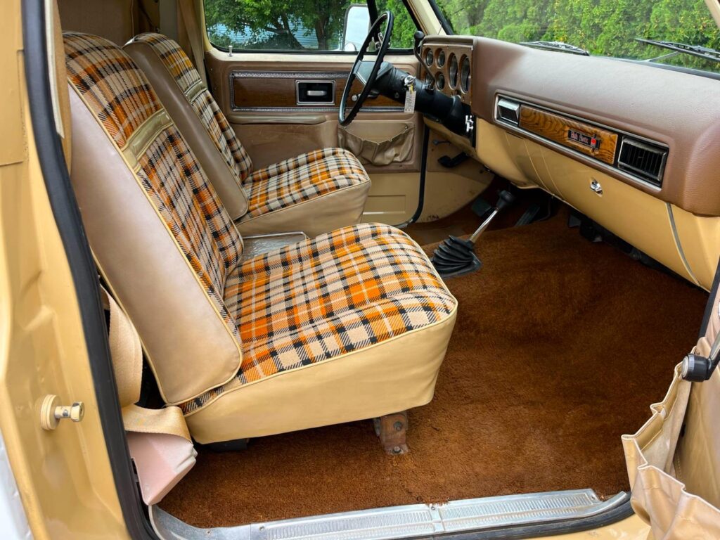 Front-side interior view of 1977 GMC Jimmy Casa Grande camper showing driver’s seat, dashboard, and partial kitchenette