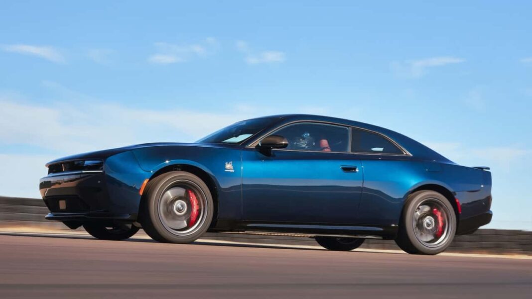 2026 Dodge Charger Daytona Scat Pack EV roaring down a coastal highway at sunset